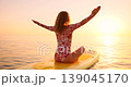 Happy young woman walking on stand up paddle sup board by the sea during summer vacation. Beautiful girl flat water paddling against sea and sky background. Healthy lifestyle concept. Slow motion 139045170