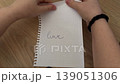 Close-up of hands ripping a piece of paper. 139051306