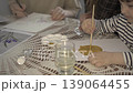 Teenager and young child painting with paints together at the table. 139064455