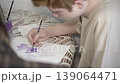 Focused redhead teenage boy painting with watercolor, high angle view. 139064471