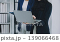 Two business people talk project strategy at office meeting room. Businessman discuss project planning with colleague at modern workplace while having conversation and advice on financial data report. 139066468