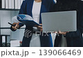 Two business people talk project strategy at office meeting room. Businessman discuss project planning with colleague at modern workplace while having conversation and advice on financial data report. 139066469
