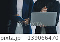 Two business people talk project strategy at office meeting room. Businessman discuss project planning with colleague at modern workplace while having conversation and advice on financial data report. 139066470