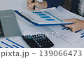 Two business people talk project strategy at office meeting room. Businessman discuss project planning with colleague at modern workplace while having conversation and advice on financial data report. 139066473