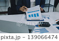 Two business people talk project strategy at office meeting room. Businessman discuss project planning with colleague at modern workplace while having conversation and advice on financial data report. 139066474