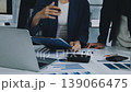 Two business people talk project strategy at office meeting room. Businessman discuss project planning with colleague at modern workplace while having conversation and advice on financial data report. 139066475