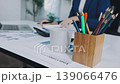 Two business people talk project strategy at office meeting room. Businessman discuss project planning with colleague at modern workplace while having conversation and advice on financial data report. 139066476