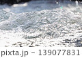 Real-time horizontal video of a super-close-up of a river flowing with clear water at a waterfall, 4K resolution, side view. The current creates air bubbles. Sound of waterfall splashing is included 139077831