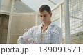 livestock farm concept of 4k resolution. Caucasian male veterinarian examining chicken eggs in a farm. 139091571