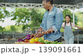 Agricultural concept of 4k resolution. African mother and daughter arranging vegetables in baskets at the garden. 139091661