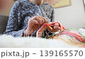 A close-up of a woman's hands enjoying crocheting with brightly colored yarn. 139165570
