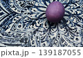 Purple easter egg rolling on a decorative plate 139187055