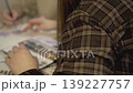Female artist in plaid shirt sketching in sketchbook, creative process and freelance concept. 139227757