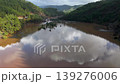 Muddy floodwaters of the Namnam River reflecting surrounding pine-forested hills in Koycegiz, Mugla, Turkey. Aerial drone view, moving forward 139276006