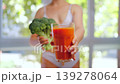Woman holding a broccoli and a glass of carrot juice. Concept of healthy eating 139278064