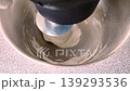 Planetary mixer kneading bread dough with a spiral hook in a metal bowl. 139293536