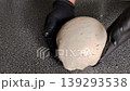 Baker with black gloves folding sourdough bread dough. 139293538