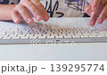 Female hands typing on computer keyboard, close up of fingers working on desktop PC, digital communication and office work concept, online activity and modern technology usage indoors, front view 139295774