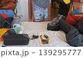 Woman packing large yellow duffel bag with climbing and camping gear at home, organizing equipment for hiking trip, travel preparation and outdoor adventure planning concept 139295777