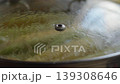 Close-up, corn cobs boiling in pot under glass lid on kitchen stove 139308646