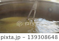 Close-up, kitchen fork pricking corn boiling in a pot to check for doneness 139308648