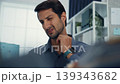 Young Latino businessman suffering shoulder pain and neck ache at office desk with computer. Office syndrome, muscle massage, overworked stress, bad posture, and health insurance injury concept. 139343682