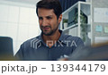 Stressed young Latin businessman having severe headache and migraine at office desk. Debt crisis, corporate burnout, mental health anxiety, business failure, and work financial frustration concept. 139344179