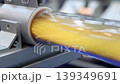 Close up of yellow granular plastic material moving through transparent industrial tubes in a modern processing system. Plastic manufacturing automation engineering and production technology concept. 139349691