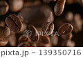 Coffee beans cascade downwards in extreme slow motion against a black backdrop highlighting the rich brown textures of roasted espresso ingredients for high quality commercial use 139350716