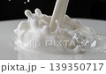 Coffee espresso droplets plunge into thick milky foam to create an energetic splash and slow circular ripples ideal for dynamic macro beverage advertising backgrounds 139350717