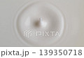 coffee pours heavily into creamy white froth creating dynamic waves and droplets suitable for advertising campaigns highlighting rich flavor and morning refreshment 139350718