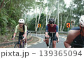 three happy young asian cyclers riding bicycle on suburban road 139365094