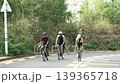 three young asian cyclers cycling uphill on suburban road 139365718
