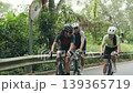 three happy young asian cyclers riding bicycle on suburban road 139365719