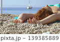 Close up of female resting on beach towel by the 139385889