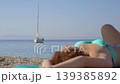 Cute, sexy redhead lies on the beach sunbathing. 139385892