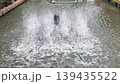 water turbine aerator splashing water in canal to increase oxygen. Wastewater treatment machine working in outdoor pond, sustainable agriculture and environmental technology in Thailand 139435522