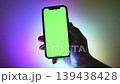 Male hand Holding Mobile Phone with Green Chroma Key Screen Mockup. Cellphone display close up. Business mockup empty blank space. VFX Motion Tracking Markers. Neon Gradient Background 139438428