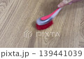 plastic hard brush scrubs when cleaning wooden table 139441039
