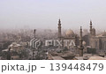 View from Cairo Citadel over Sultan Hassan Mosque and Al-Rifa'i Mosque, Egypt, with multiple minarets piercing the smoggy sky above the ancient city center. 139448479
