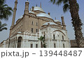 Muhammad Ali Mosque at Cairo Citadel photographed from courtyard level, Egypt, showing full facade with white domes, tall minaret, colonnaded arcade and tropical palms. 139448487