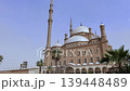 Wide shot of Muhammad Ali Mosque complex, Cairo Citadel, Egypt, with large central dome flanked by smaller domes, decorative minarets and colonnaded entrance portico. 139448489