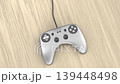 Silver wired game controller on a wooden table 139448498