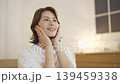 A middle-aged woman doing skin care in the living room at night 139459338