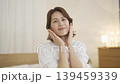 A middle-aged woman doing skin care in the living room at night 139459339