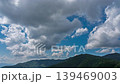 縮時攝影：無數朵白雲飄過明媚的夏日天空，山脈被鬱鬱蔥蔥的綠色植被覆蓋。 139469003