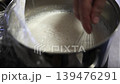 Whisking Frothy White Batter in a Metal Pot with a Hand Whisk 139476291