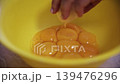 Adding Fresh Egg Yolks into a Yellow Bowl for Baking 139476296