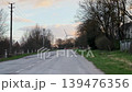 Quiet Rural Road Leading to Wind Turbine at Soft Sunset 139476356