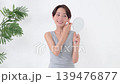 一位女士正在鏡子前檢查自己的皮膚。 139476877